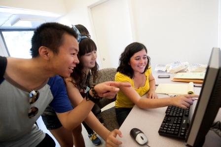 Students laugh and point at a computer screen