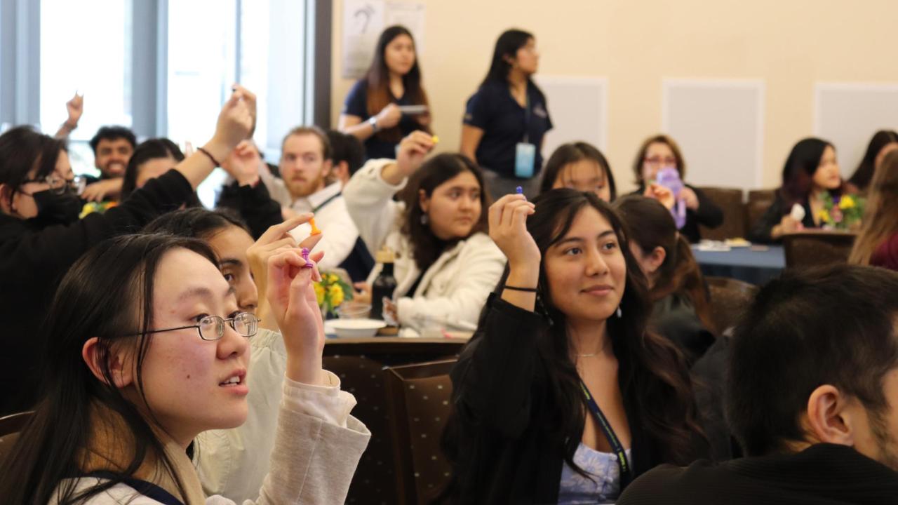 Students hold up game pieces