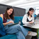 Two UC Davis students work side-by-side inside one of the study booths in the Teaching and Learning Complex