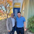 Two people (Dean Bradford and Christian Caceres) standing in front of The Grove.